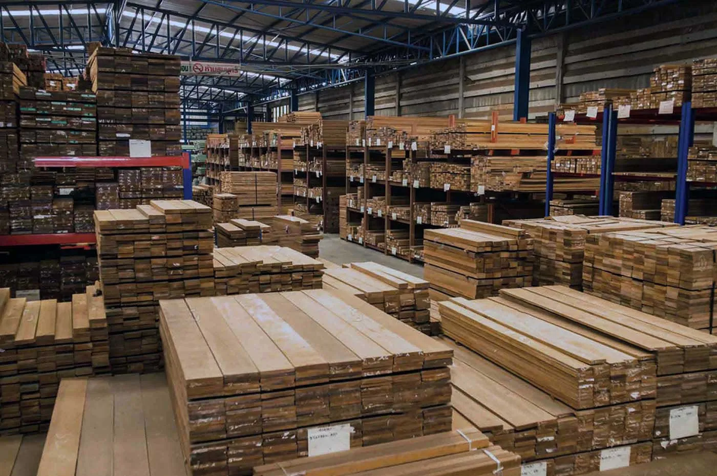 Almacén de una maderería con tablones de madera apilados en estanterías.